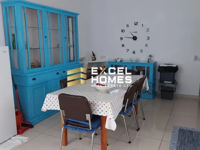 a room with a table and chairs and a table with a blue blanket