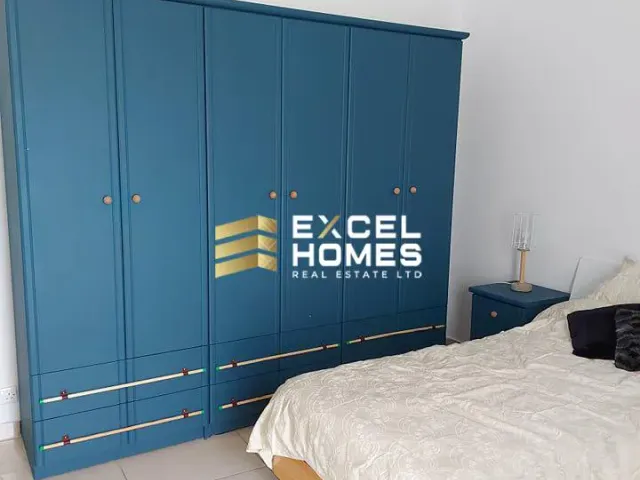 a bed room with a blue bedspread and a blue wall