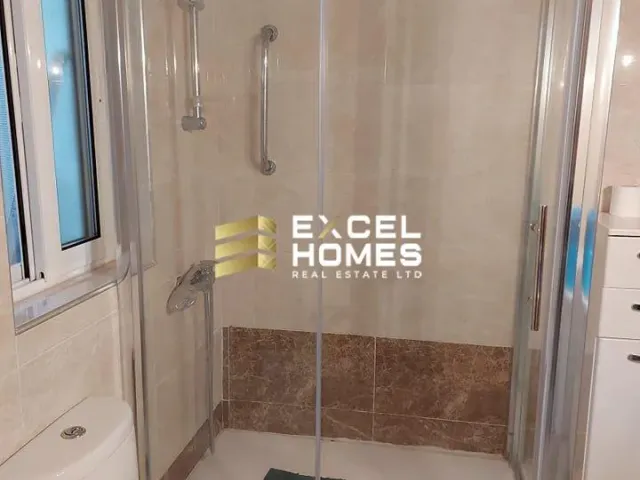 a shower stall with a glass door and a shower curtain
