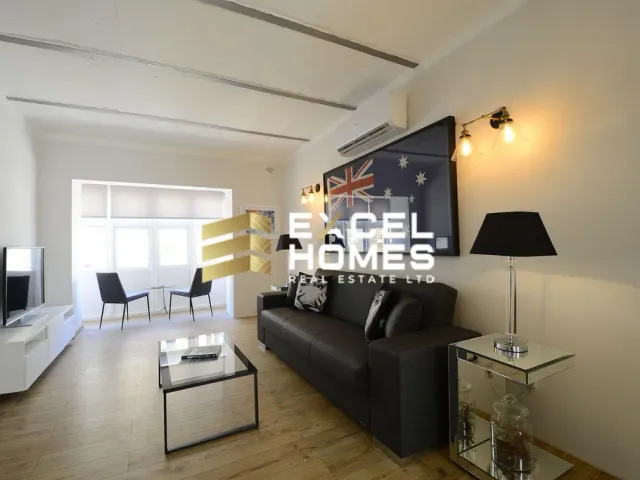 a living room with a couch, coffee table and a lamp 