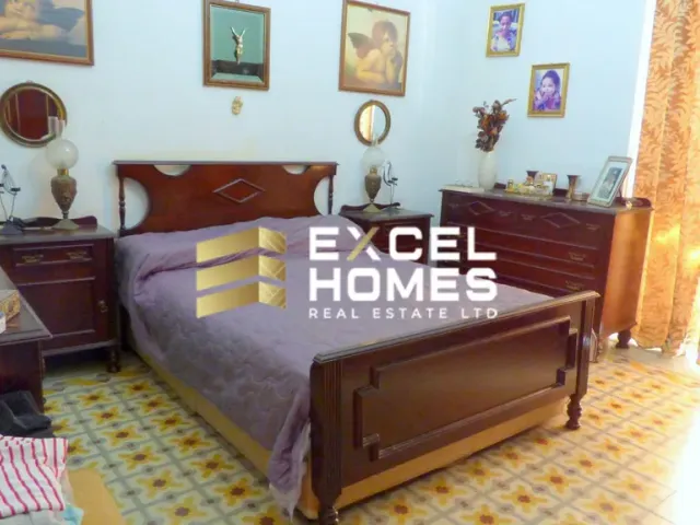 a bed room with a bed, chair, and a painting on the wall