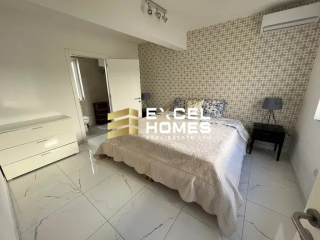 a bedroom with a bed, a table, and a mirror 