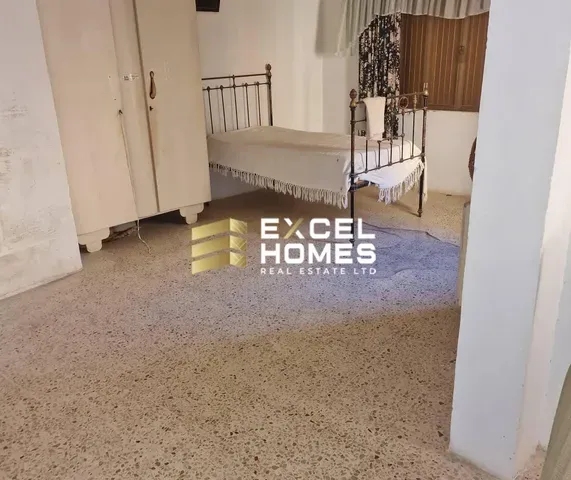 a room with a bed, a rug, and a painting on the wall