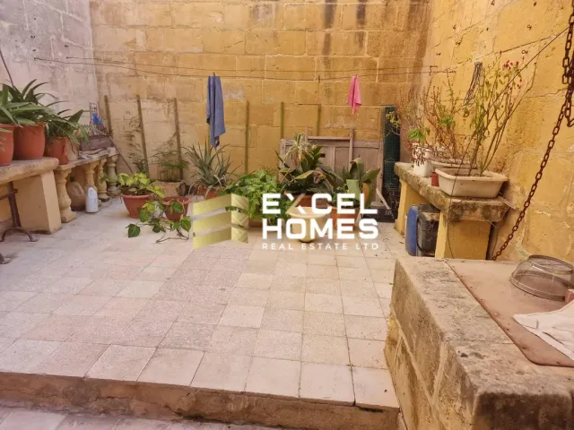 a garden with plants and a table with a basket