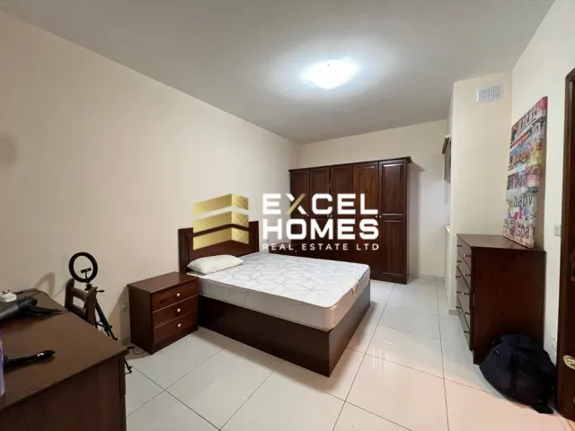 a bedroom with a bed, desk, and a lamp