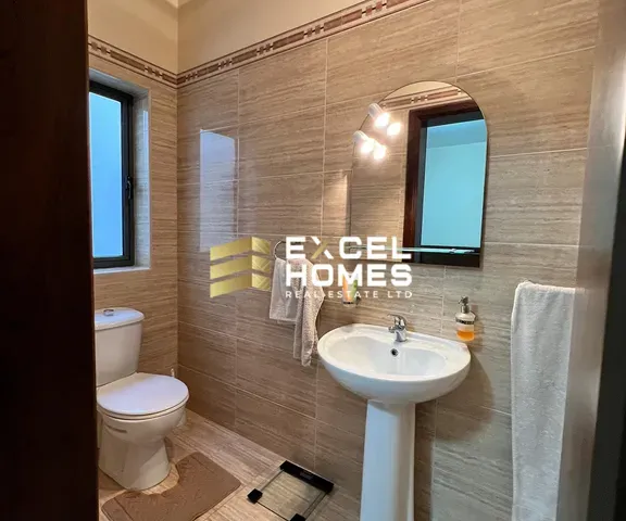 a bathroom with a toilet, sink, and mirror