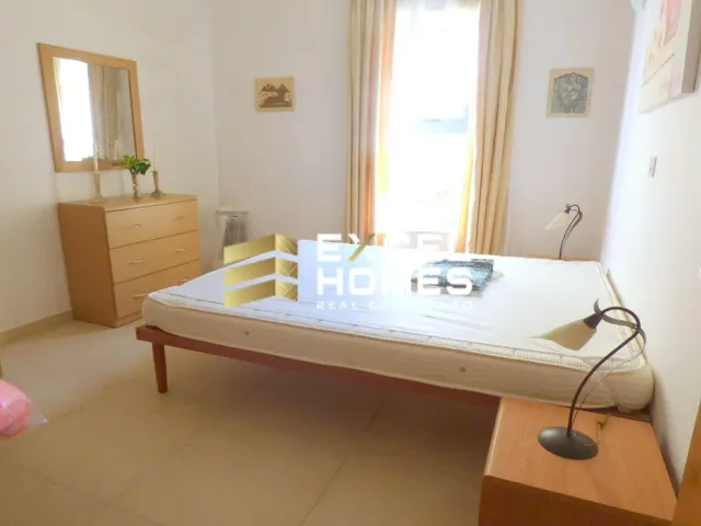 a bed with a white bedspread and a white chair