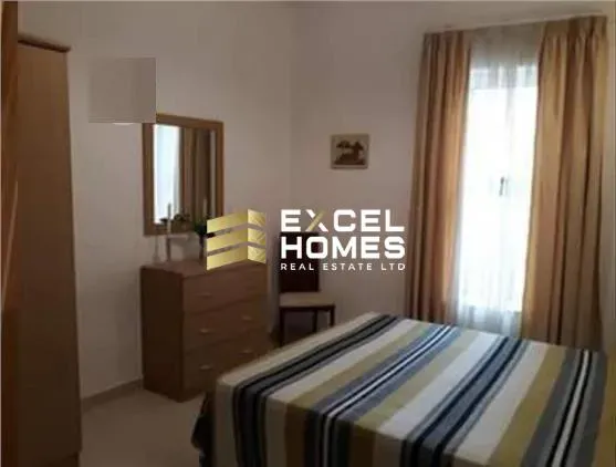 a bedroom with a bed, desk, and a lamp