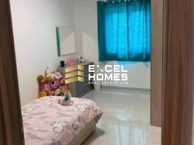 a bedroom with a bed, desk, and window 