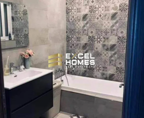 a bathroom with a bath tub, mirror, and a painting on the wall 