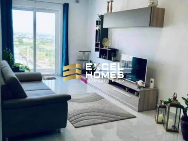 a living room with a couch, chair, tv and a window 