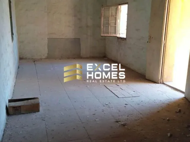 a room with a wooden floor and a wall with a wall of bricks