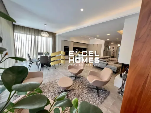 a living room with a couch, chairs, and a table 