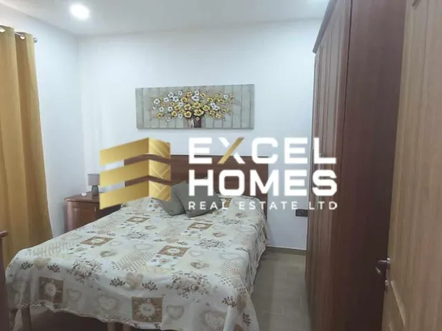 a bedroom with a bed, desk, and a lamp