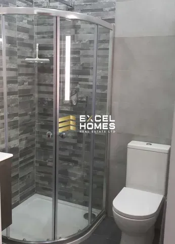 a bathroom with a toilet and a shower stall