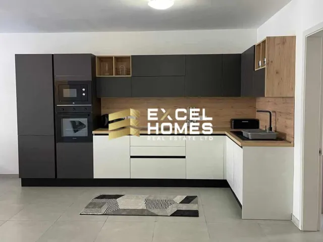 a kitchen with a refrigerator, microwave, and a sink