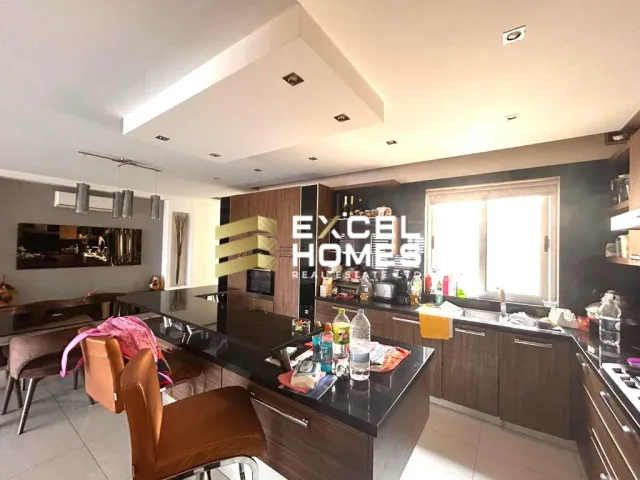 a kitchen with a table, chairs, and a refrigerator