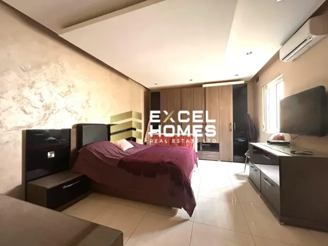 a room with a couch, chair, and a television