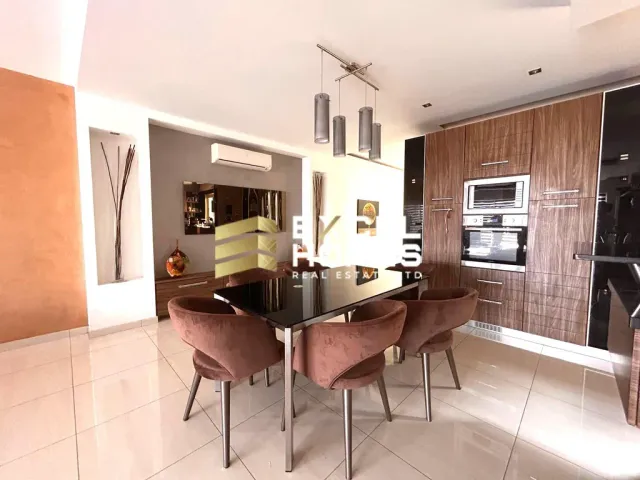a kitchen with a table and chairs and a refrigerator