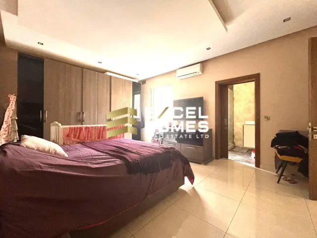 a bedroom with a bed, a desk and a window