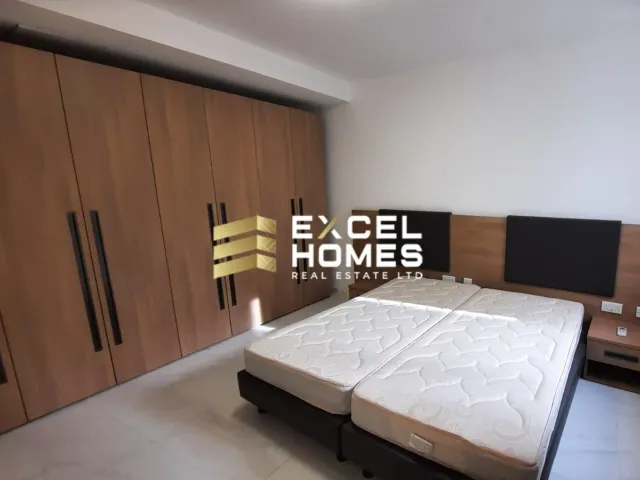 a bedroom with a bed, desk, and a lamp