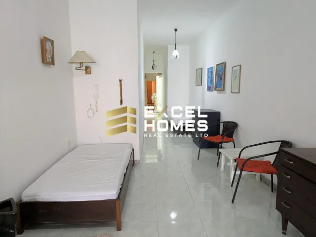 a bedroom with a bed, chair, and a desk