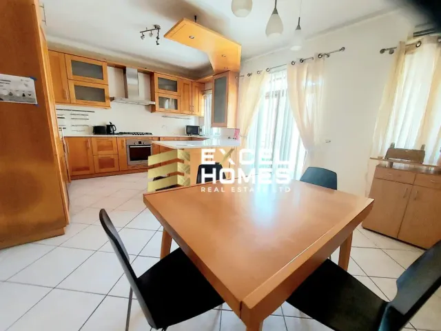 a kitchen with a table and chairs and a refrigerator