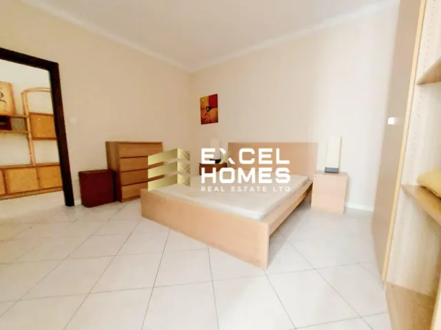 a bedroom with a bed, a dresser, and a lamp