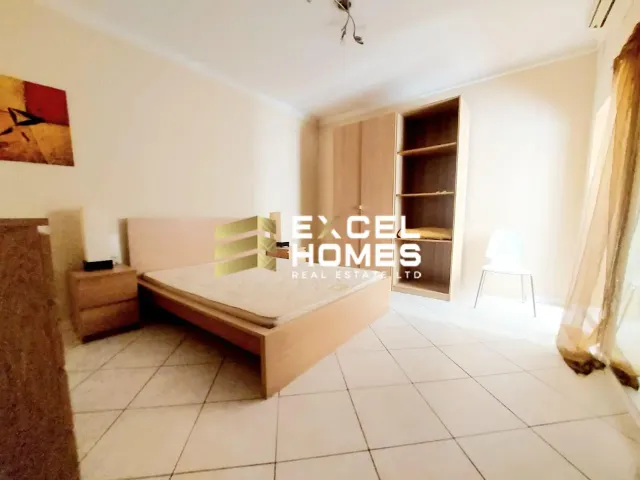 a bedroom with a bed, a desk and a window