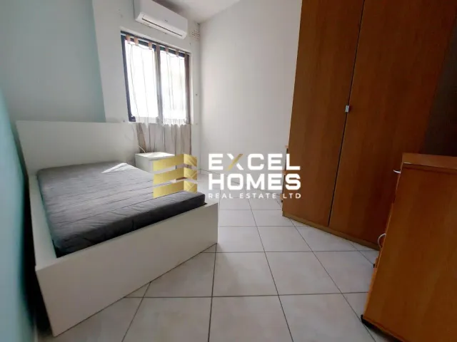 a bedroom with a white bed and a white wall