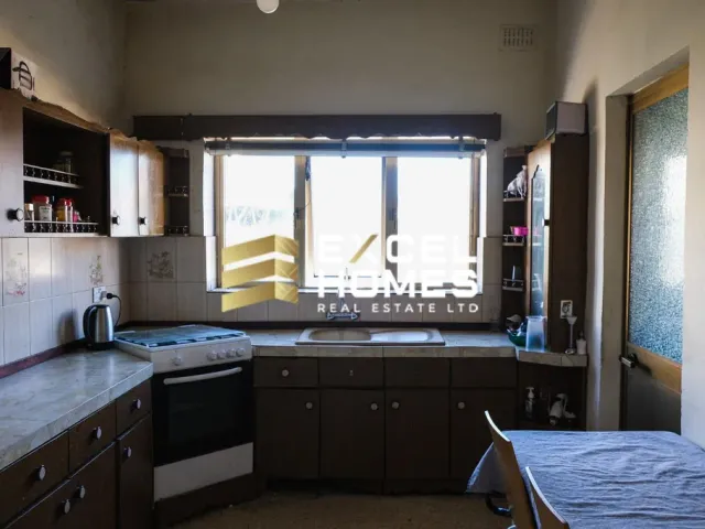 a kitchen with a sink, a window, and a window blind 