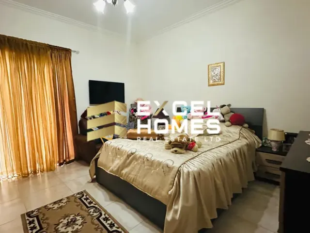 a bedroom with a bed, desk, and a lamp