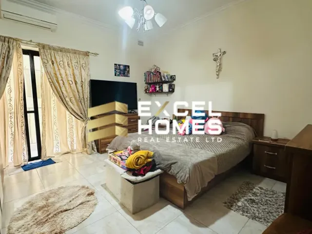 a bedroom with a bed, table, and a lamp