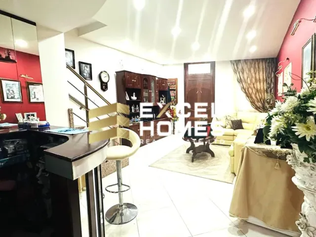 a kitchen with a table and a vase of flowers