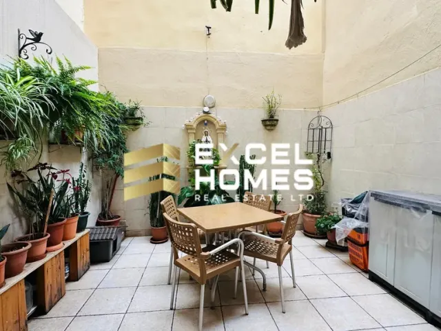 a patio with a table and chairs and a plant
