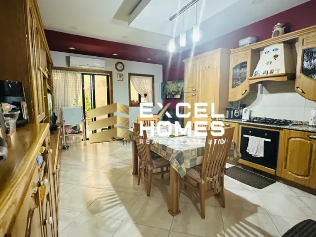 a kitchen with a table, chairs, and a refrigerator