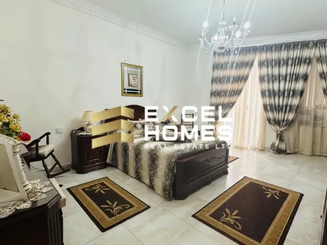 a living room with a bed, chair, and a table