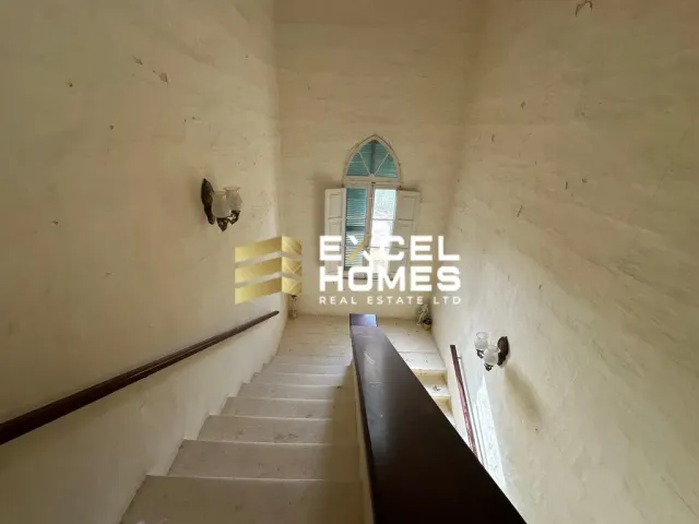 a stairway leading to a bathroom with a white wall