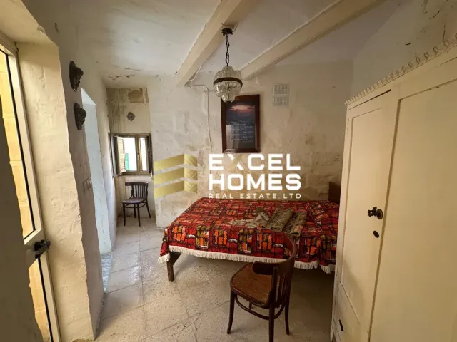 a bedroom with a bed, table, and a window