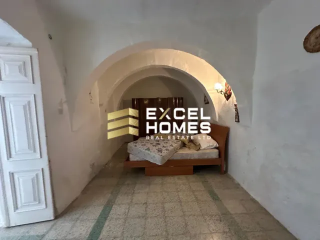 a bedroom with a bed, a lamp and a wall