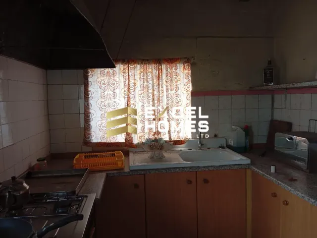 a kitchen with a sink, stove, and window