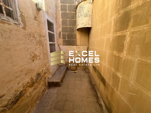 a wall with a few benches and a building