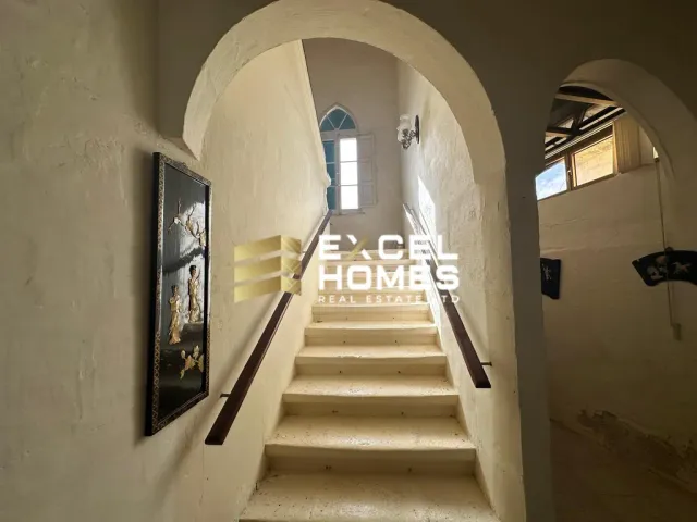 a hallway with a staircase leading to a stairway