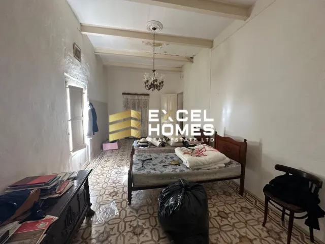 a bedroom with a bed, desk, and a painting