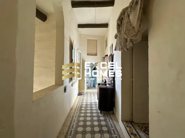 a hallway with a door leading to a room with a white wall