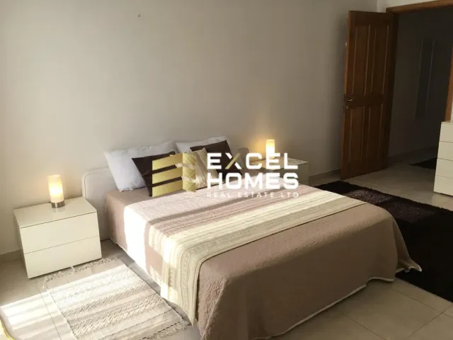 a bed room with a bed, table, and lamps