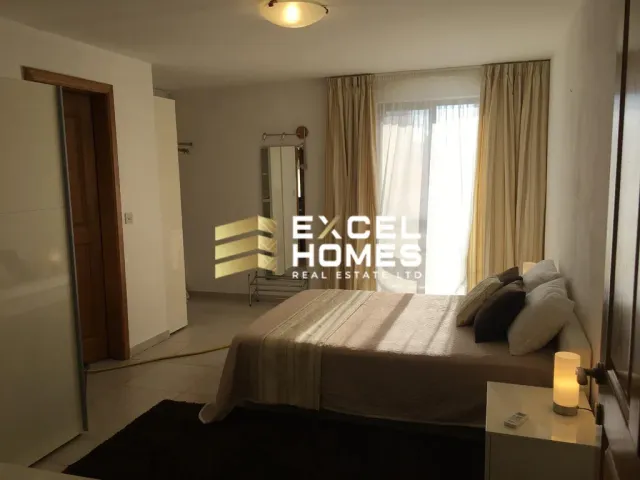 a bedroom with a bed, a desk and a window