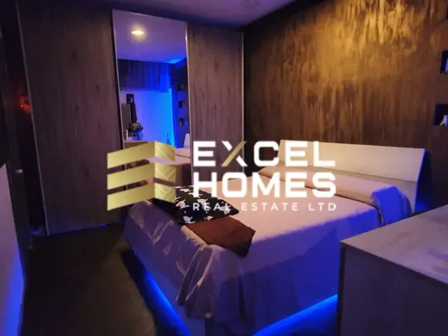 a hotel room with a bed, desk, and television 