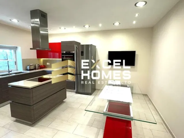 a kitchen with a refrigerator, sink, and a tv