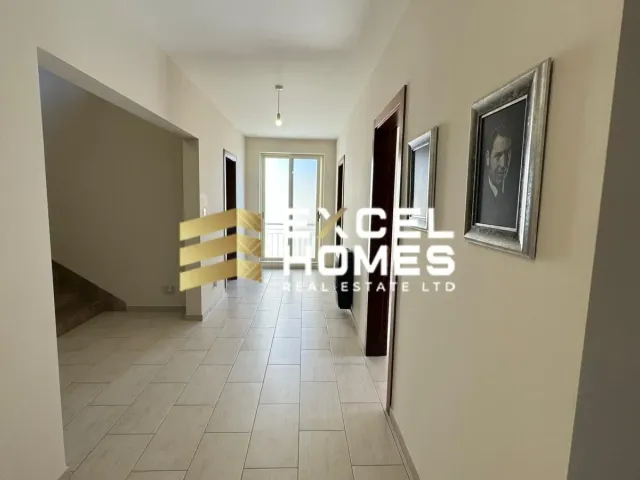 a hallway with a white wall and a blue floor